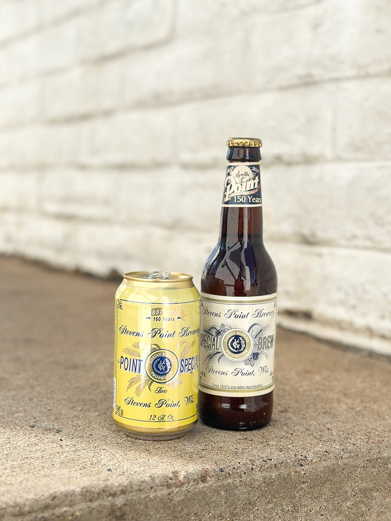 A bottle features a 1800's label reproduction. Next to it is a yellow can of Point Special beer